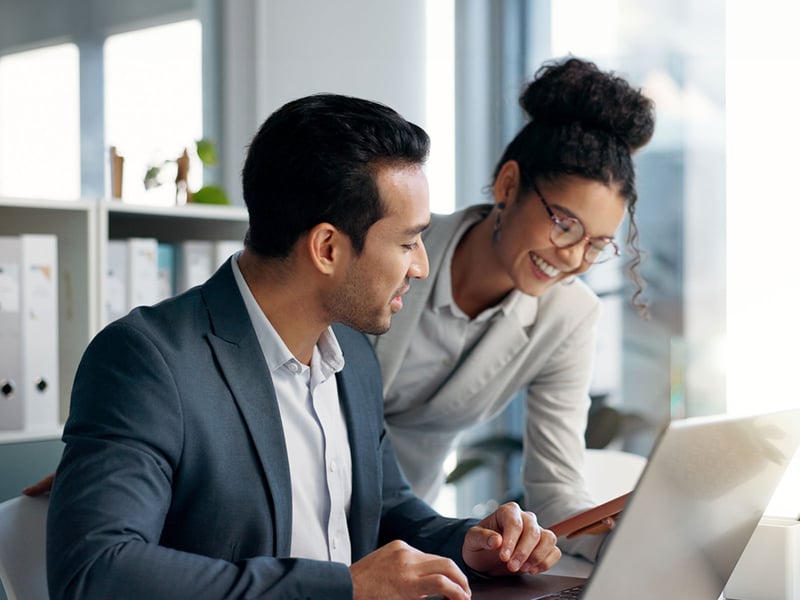 Woman helping man with finances at a computer