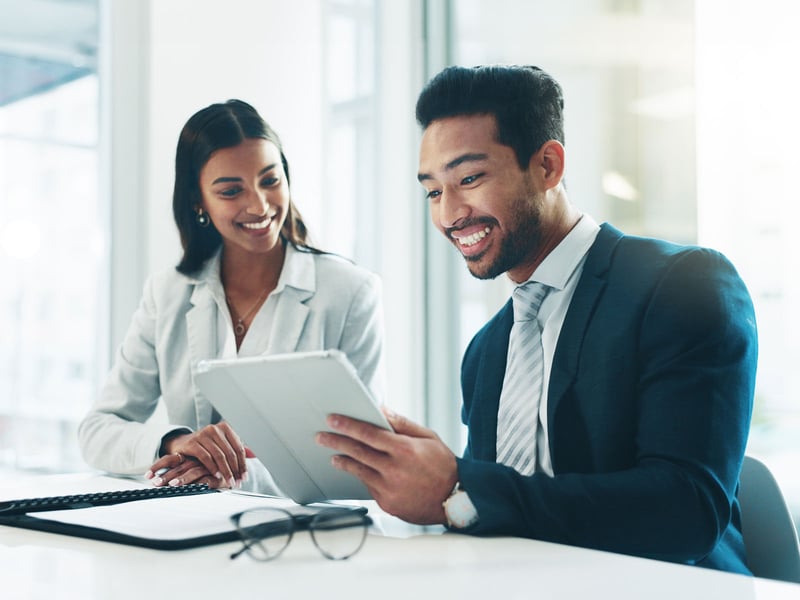 Woman and man looking over reports on an ipad