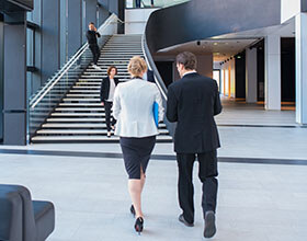 business people chatting as they walk in an atrium 